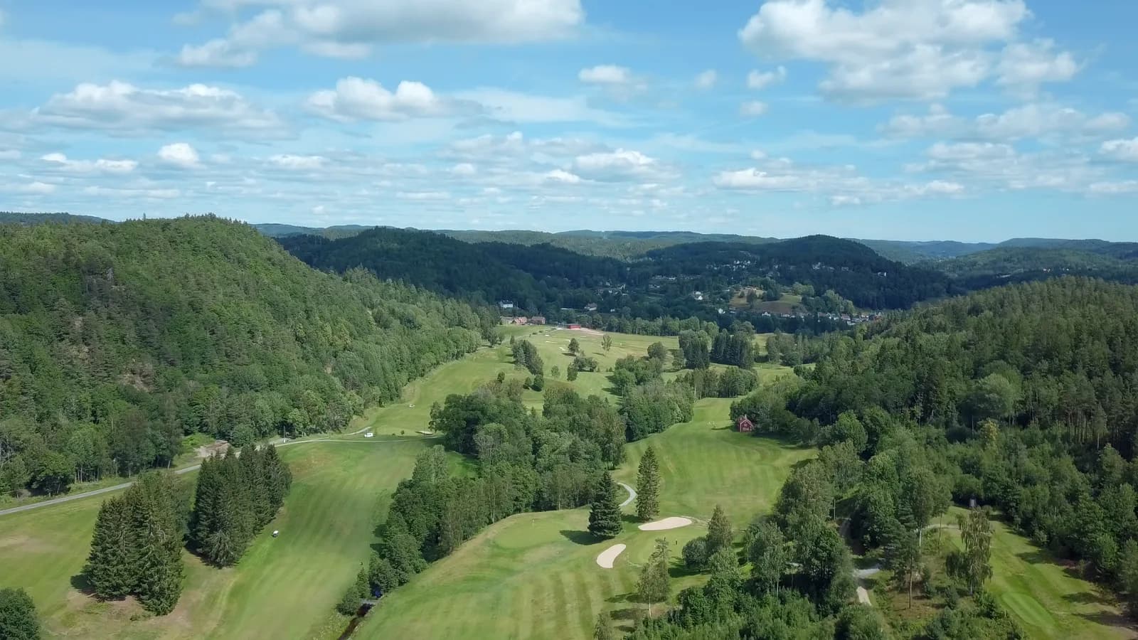 Aerial view of Arendal & Omegn Golf Club with undulating forest terrain and fairways at Nes Verk