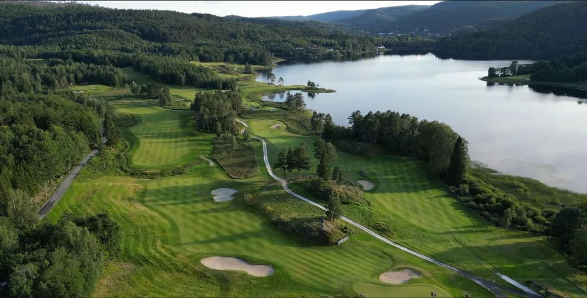 Aerial view of Bjaavann Golf Club showing the course around Lake Bjåvann with fairways, greens, bunkers and forest landscape
