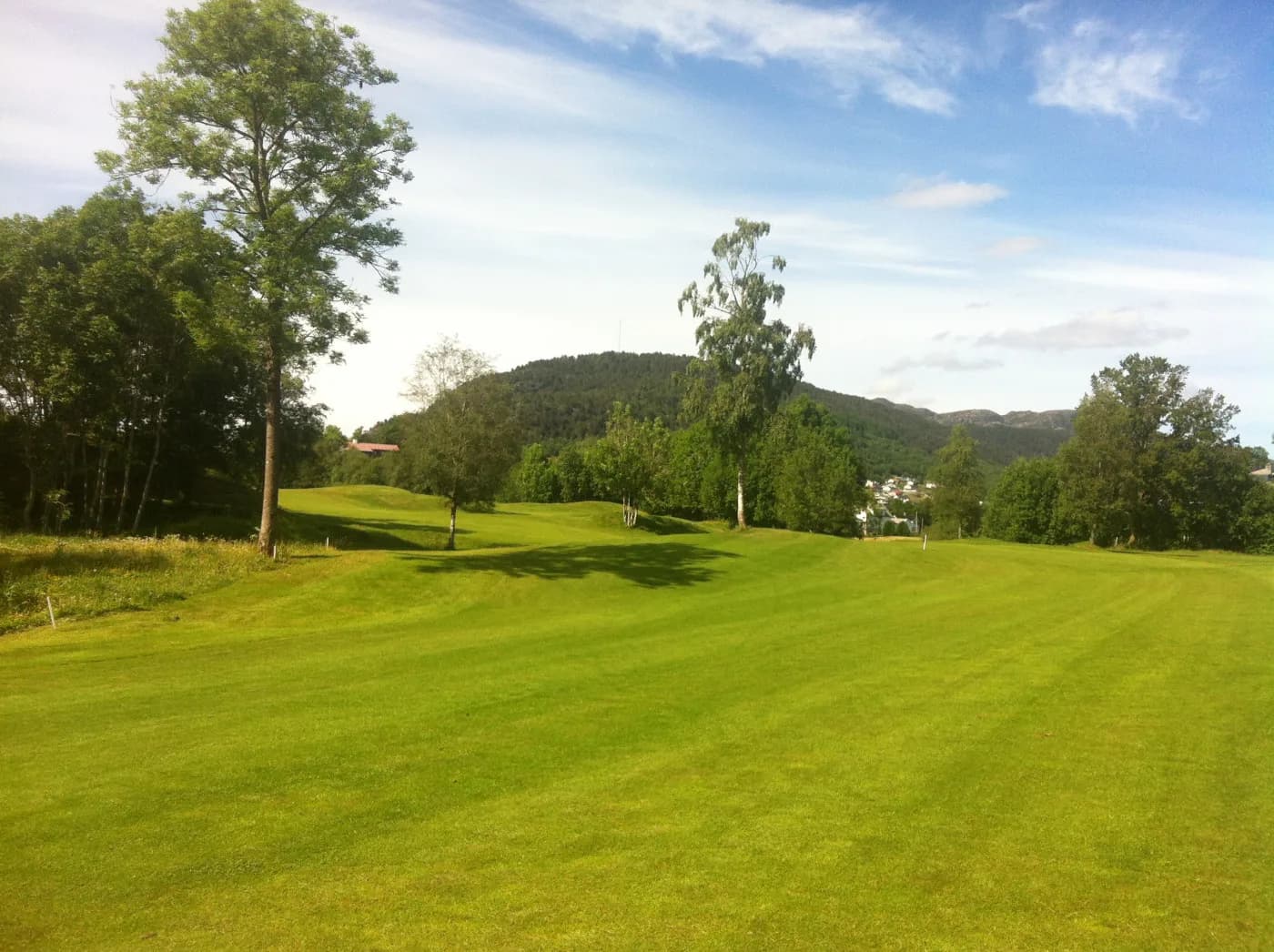 Fairway at Bjørnefjorden Golf Club with view of fjord, mountains and Folgefonna glacier in the background