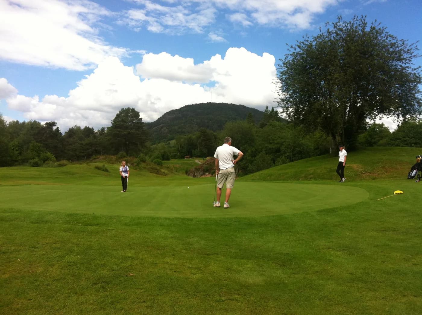 Green with view of Folgefonna glacier at Bjørnefjorden Golf Club in park and forest terrain