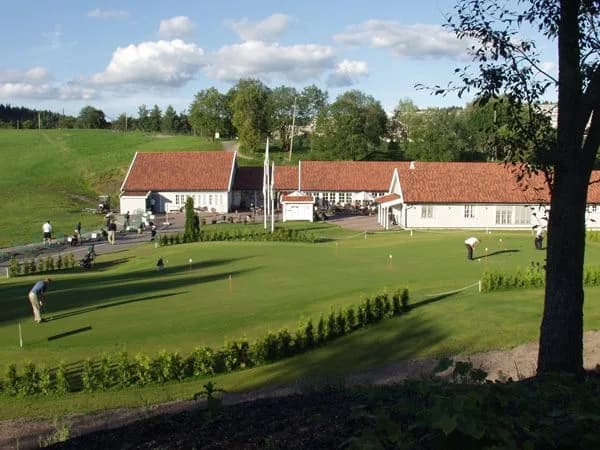 Overview of Groruddalen Golf Club with green and fairway surrounded by trees