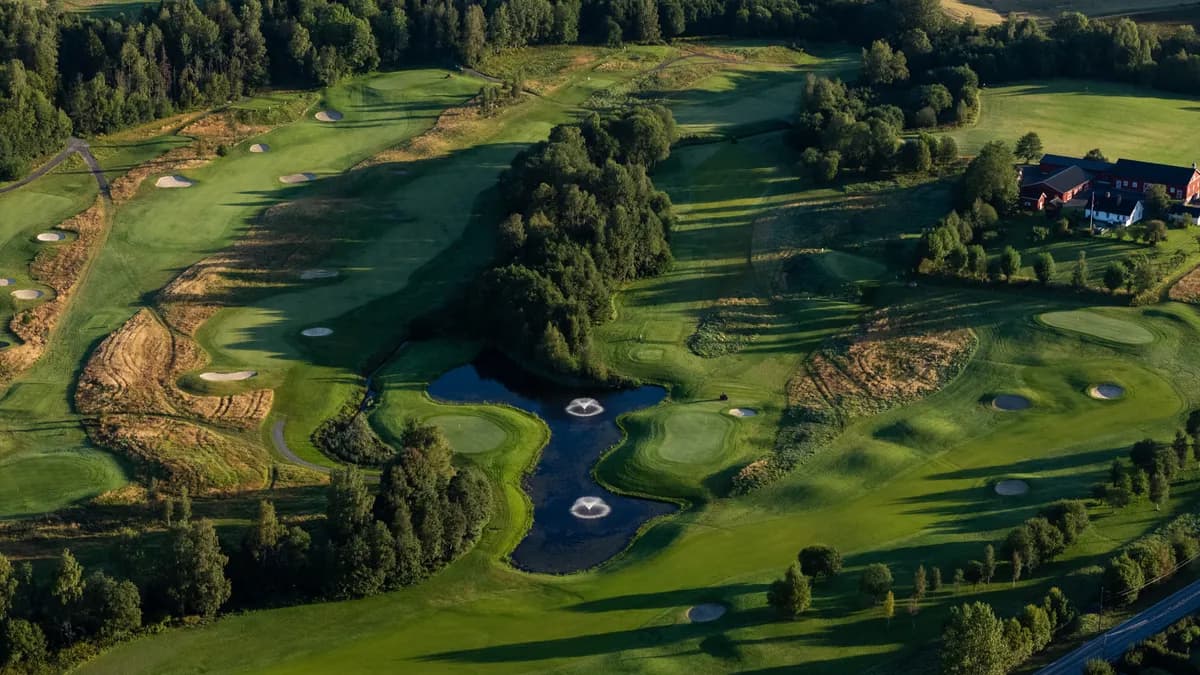 Aerial view of Haga Golf Club with fountains in water hazards, bunkers, clubhouse and green fairways in Bærum