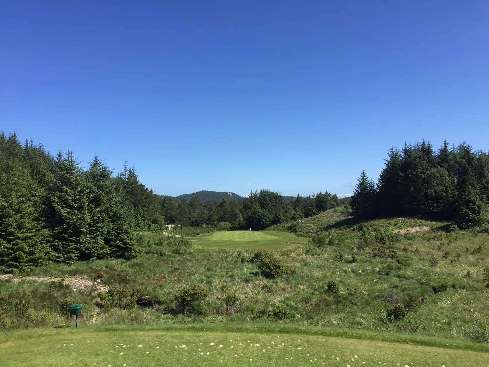 Fairway at hole 2 at Haugaland Golf Club surrounded by forest and natural terrain