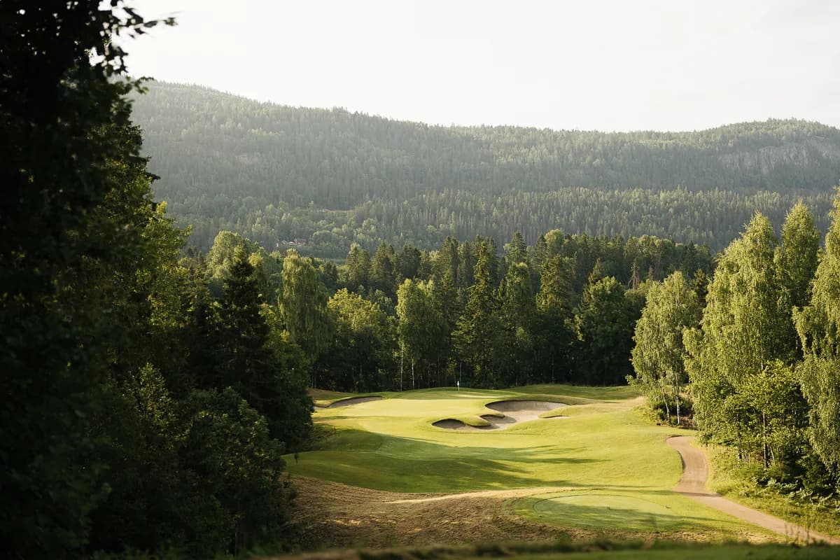 Fairway with bunkers surrounded by forest and hills at Holtsmark Golf Club designed by Robert Trent Jones II