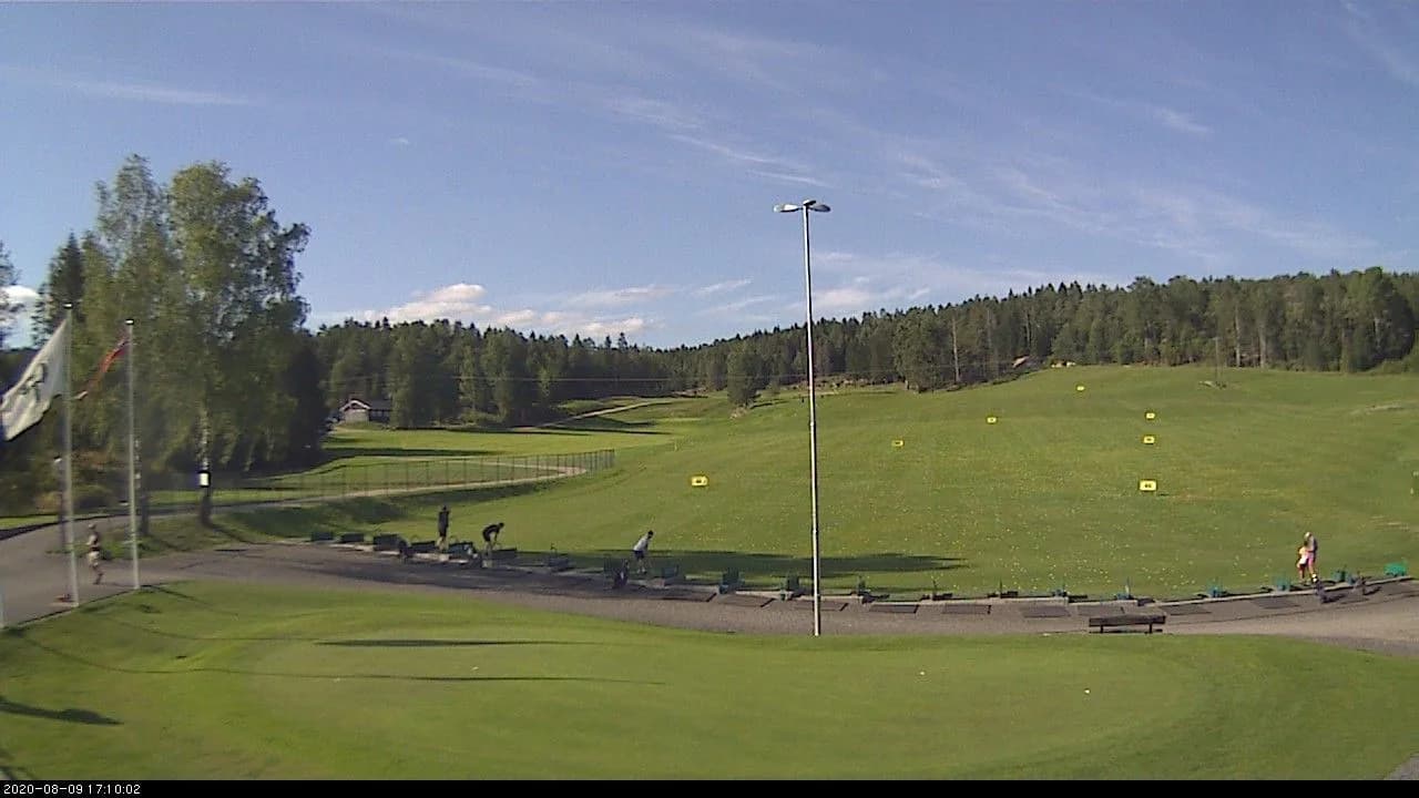 Driving range at Kjekstad Golf Club with modern practice facilities in forest setting