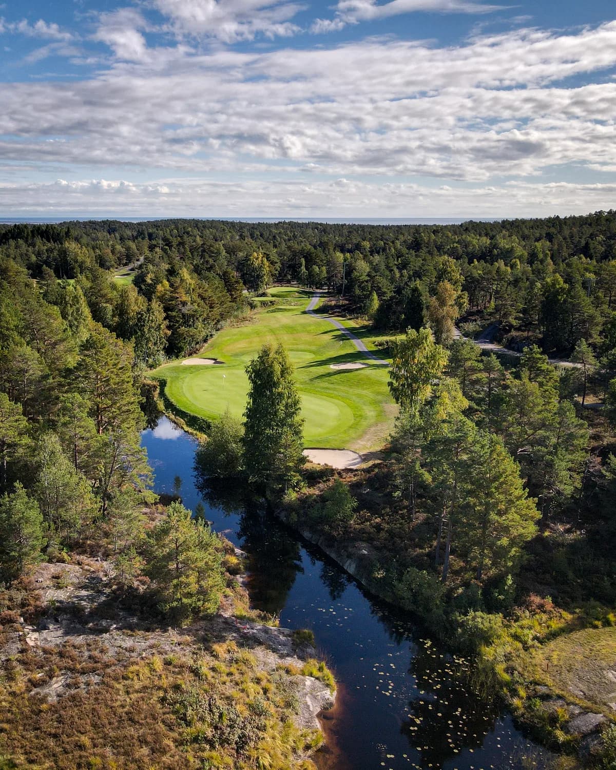 Aerial view of Kragerø Golf Club with fairways, greens and forest terrain by the coast