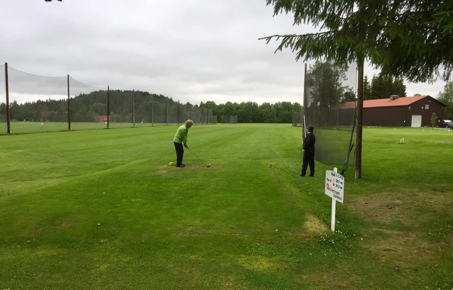 Driving range at Lillestrøm Golf Club with players and clubhouse in the background