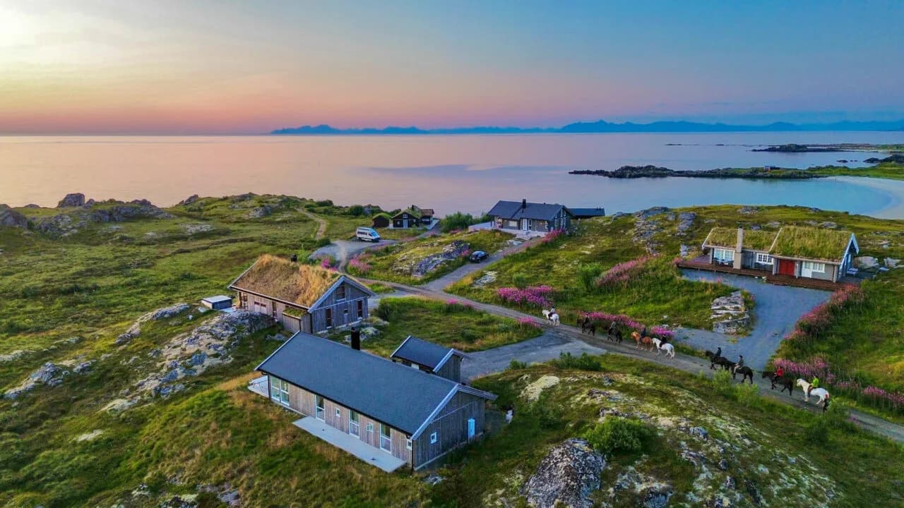 Flyfoto av Lofoten Links med fairways, bunkere og dramatisk fjelllandskap ved havet