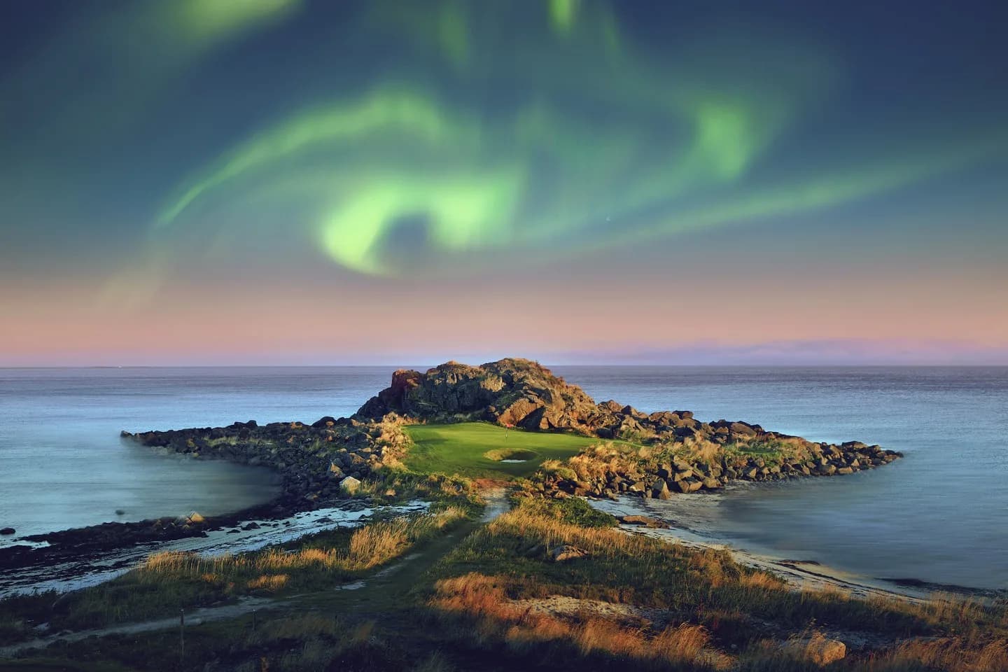 Hull 2 på Lofoten Links med nordlys over signaturhullet ved kysten