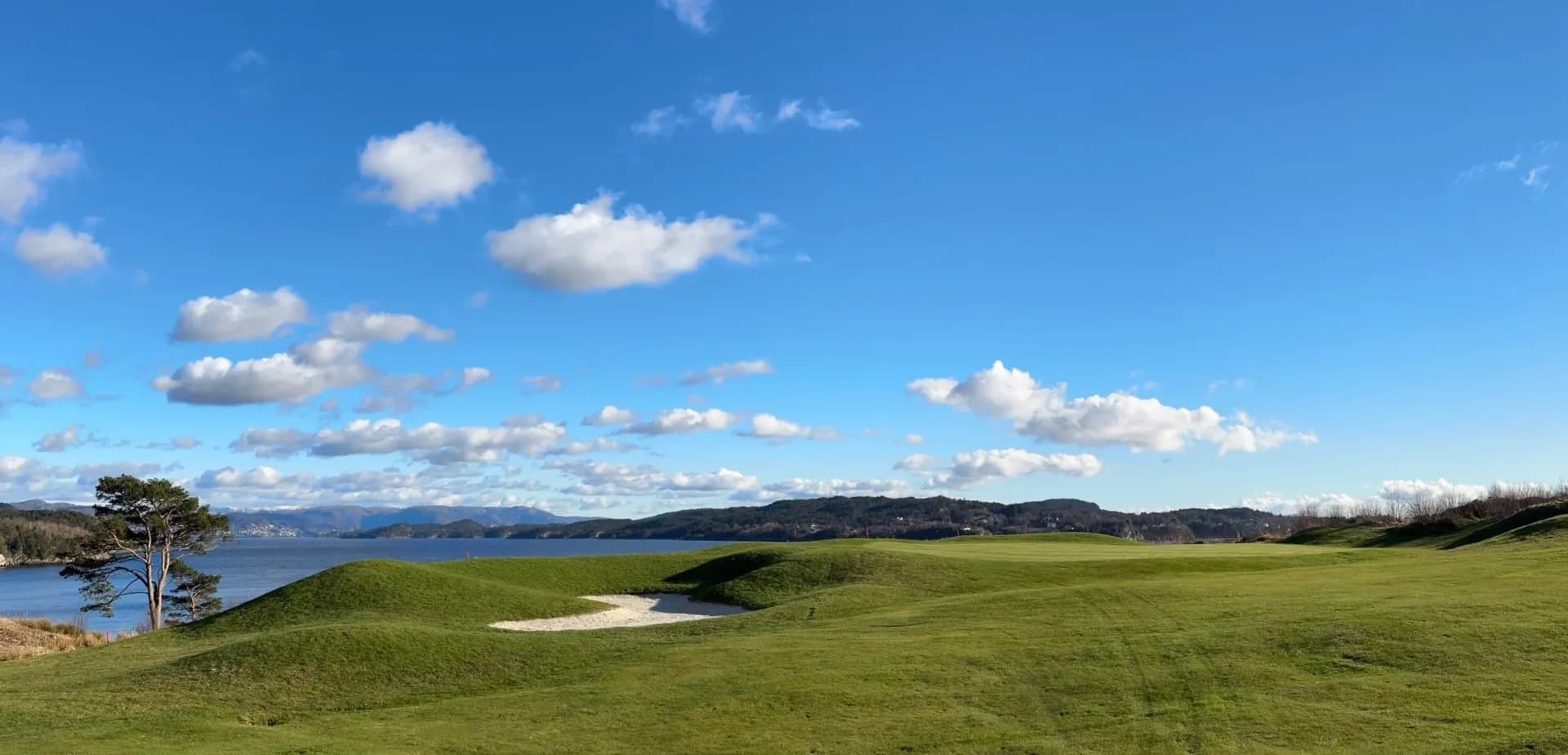 Overview of Meland Golf Club with fairways surrounded by lush forest and natural surroundings