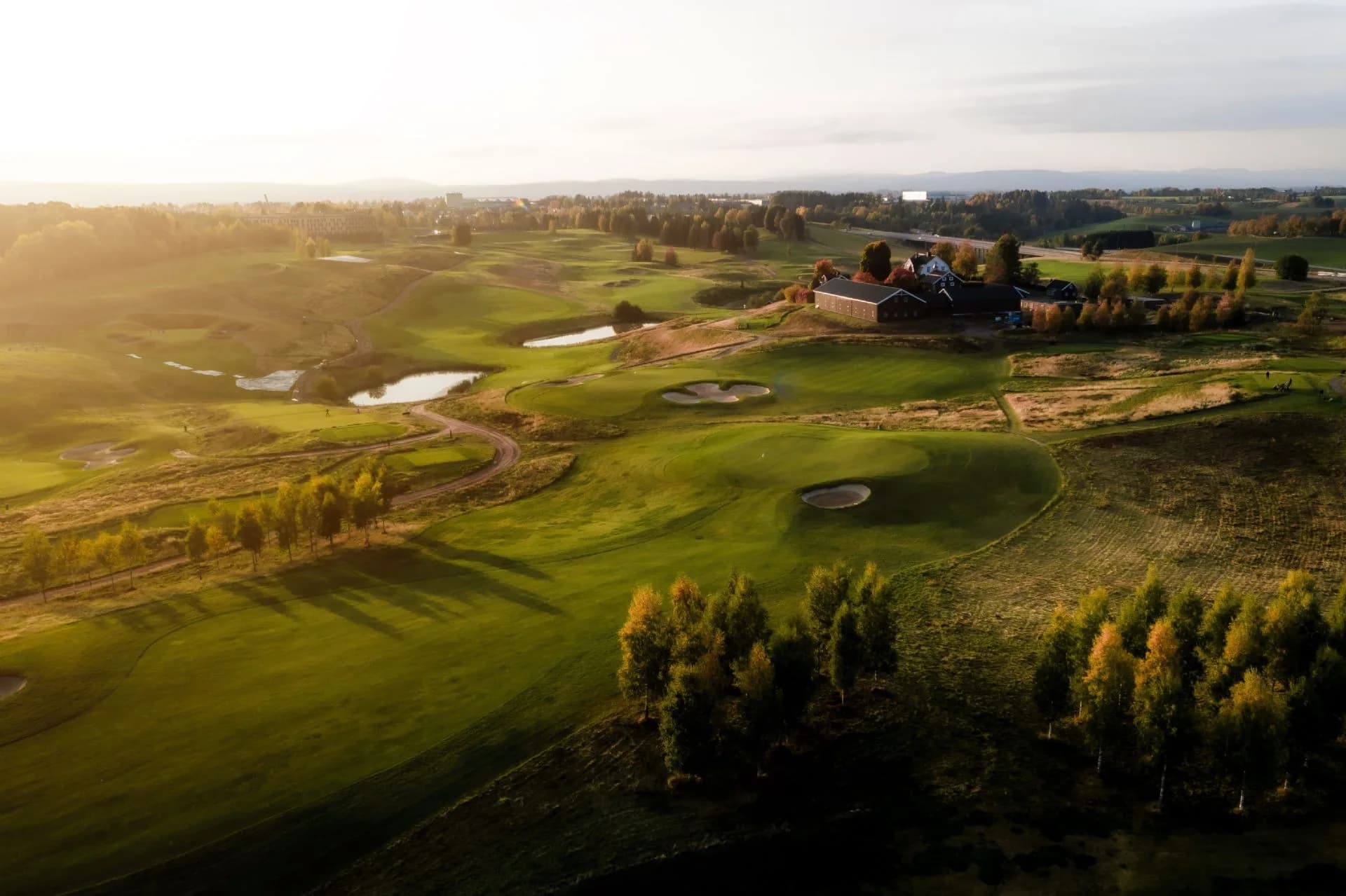 Hole 6 at Miklagard Golf in warm evening light with fairway and bunkers in Ullensaker