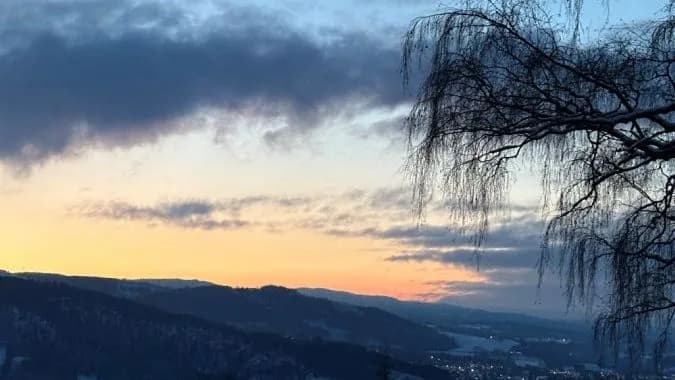 View over Mjøsen Golf Club towards Lake Mjøsa at sunset with fairway in foreground