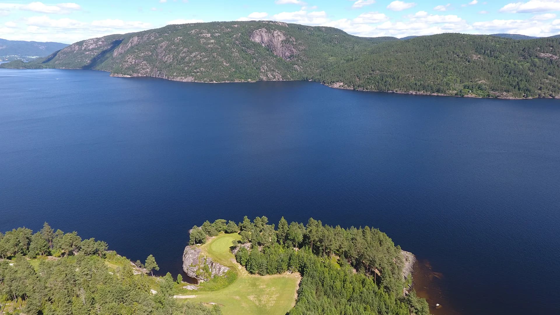 Hole 15 at Norsjø Golf Club from aerial view with fairway and green surrounded by forest