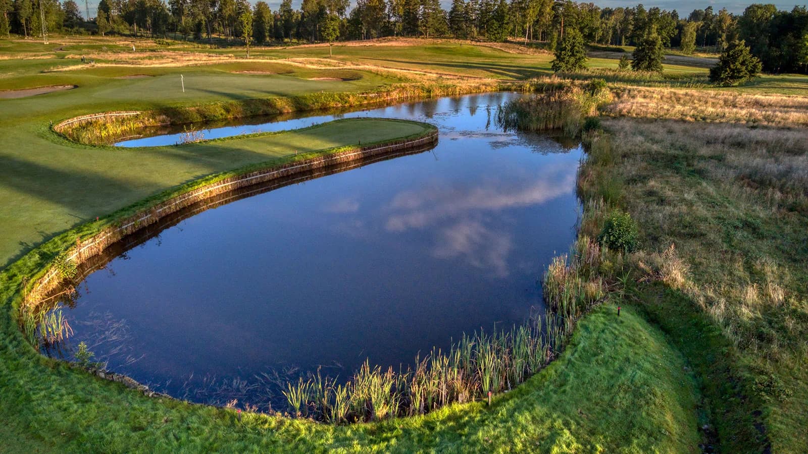 Hole 13 at Nøtterøy Golf Club seen from above, par 3 with water hazard in front of green