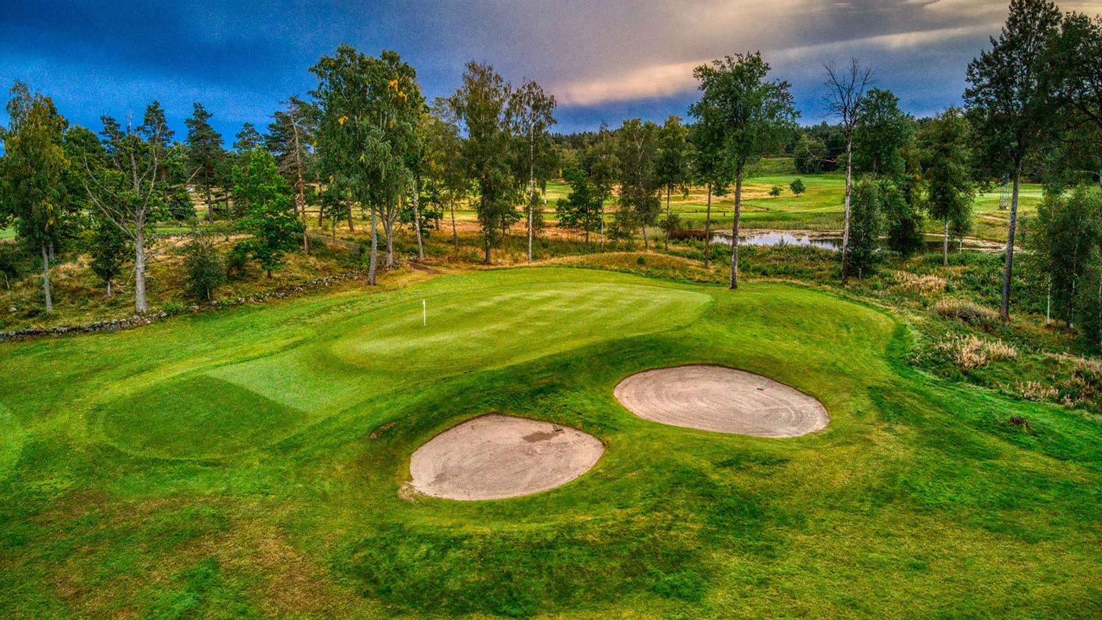 Hole 8 at Nøtterøy Golf Club from above, par 3 with green surrounded by forest