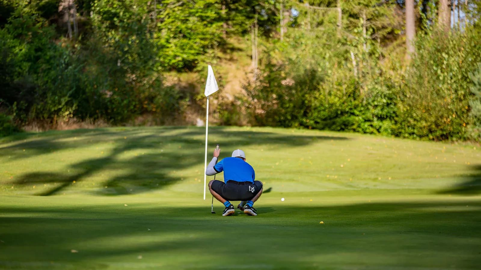 Player preparing to putt on green at Nøtterøy Golf Club with flag