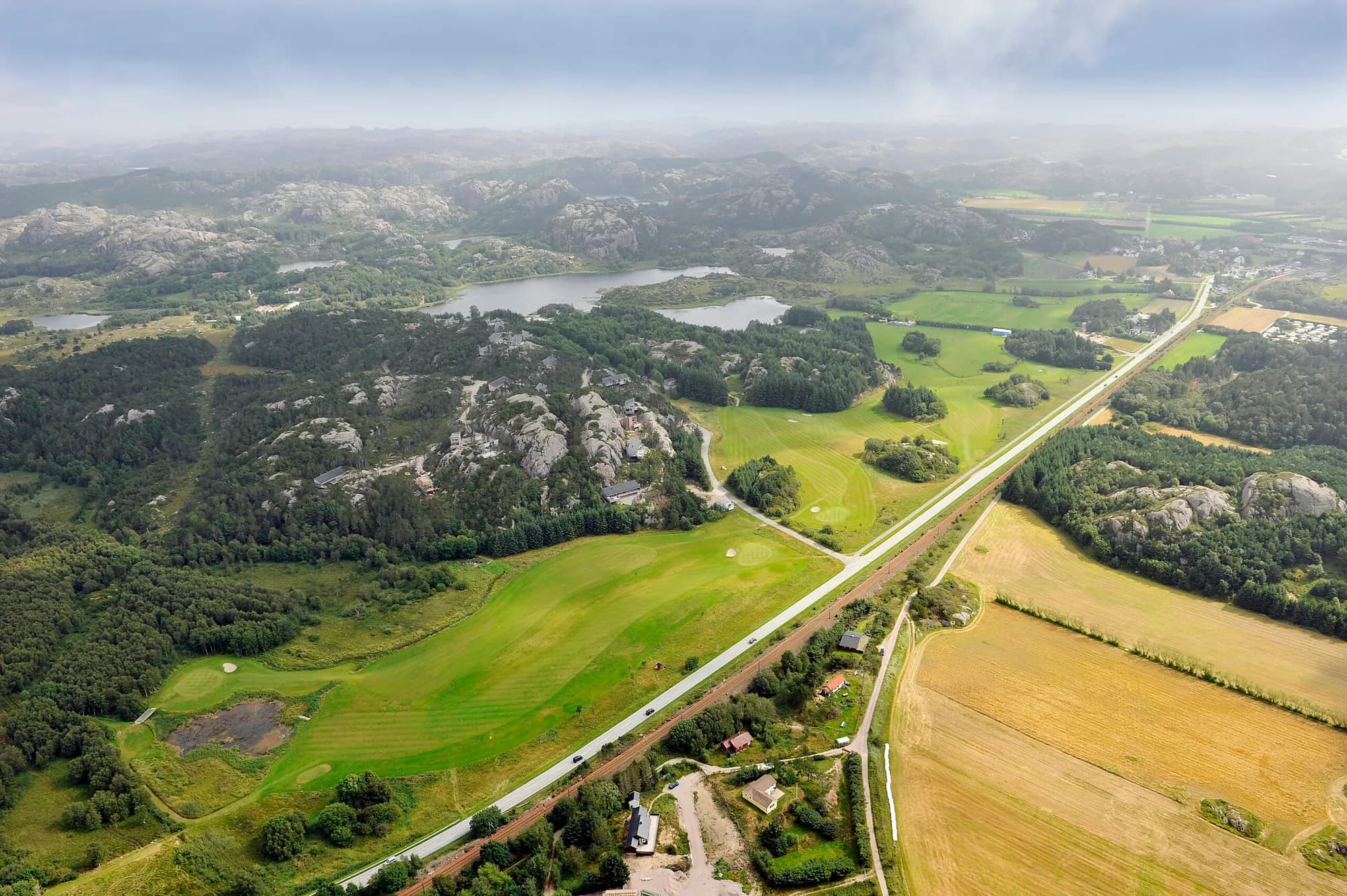 Driving range and clubhouse at Ogna Golf Club with the characteristic rock formations of Jaeren