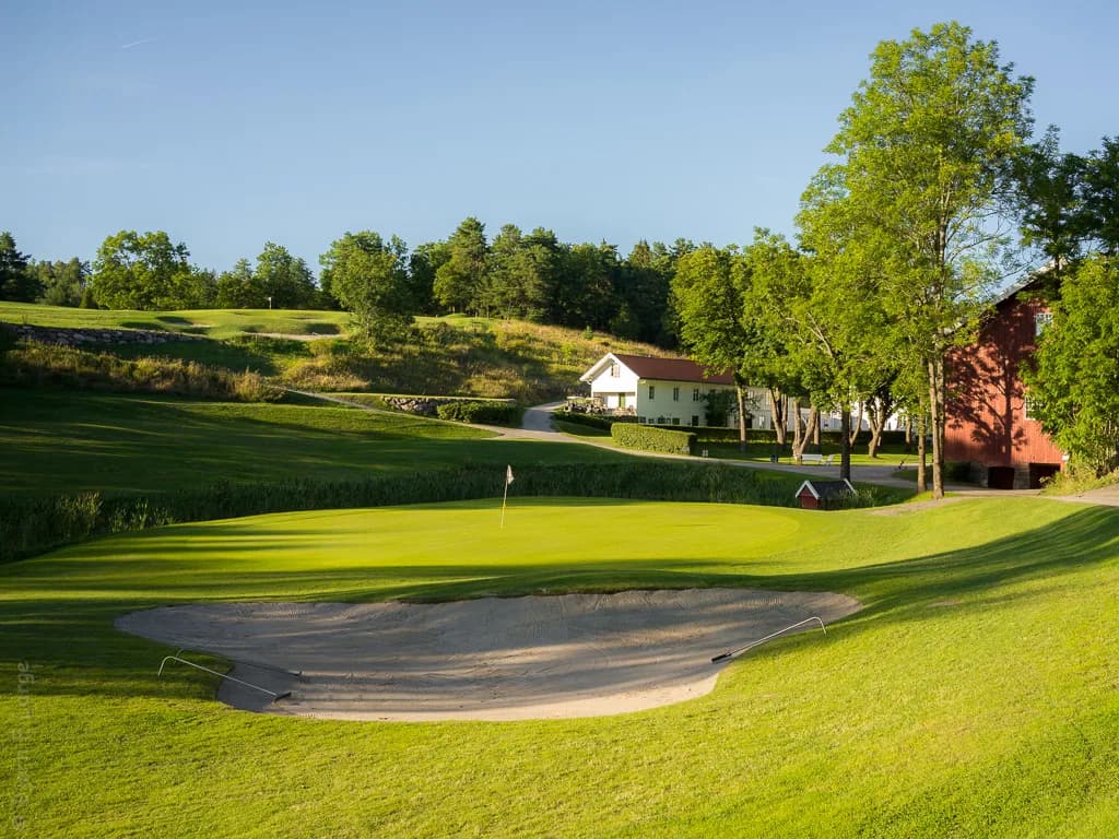 Hull 11 på Oustøen Country Club med grønn og klubbhuset i bakgrunnen ved Oslofjorden