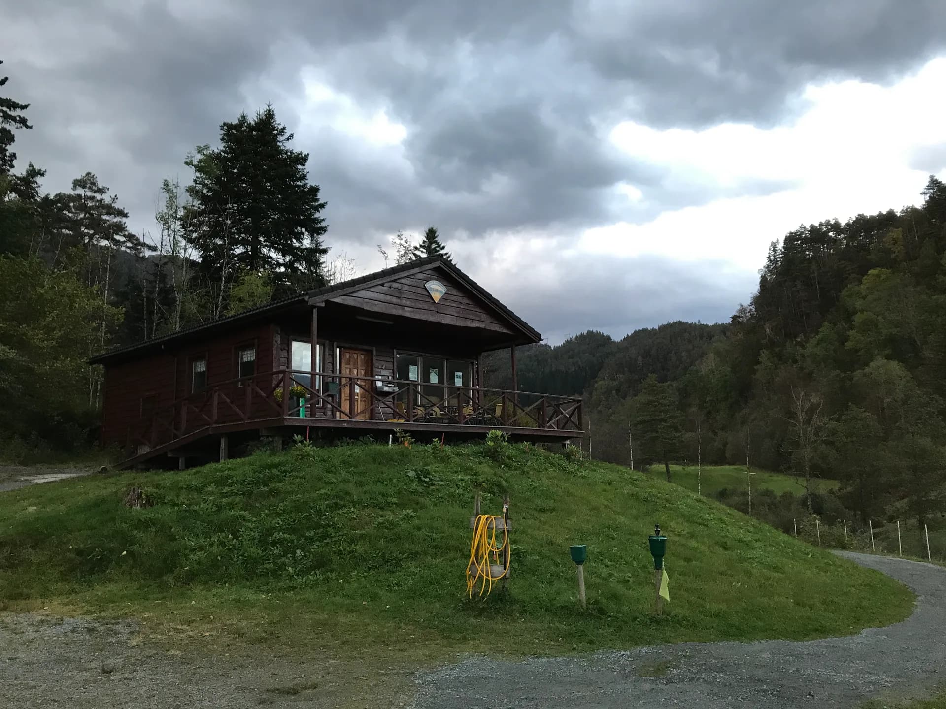 Hole 9 at Sauda Golf Club with clubhouse and view over Saudasjøen