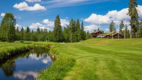 Hole 18 at Sorknes Golf Club with clubhouse in the background surrounded by pine forest
