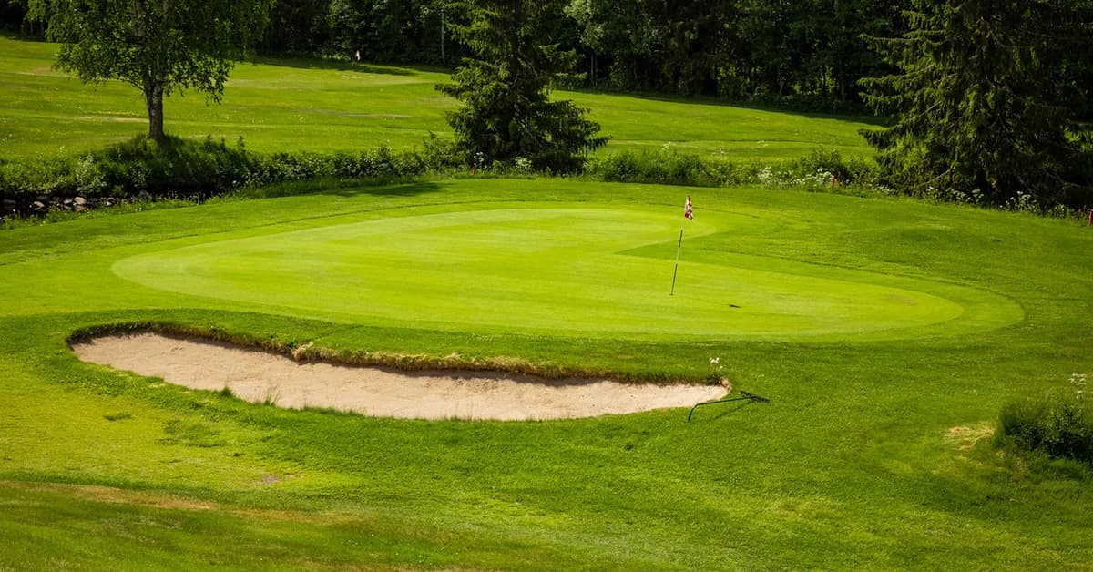 Overview of Sorknes Golf Club with clubhouse and golf course in pine forest terrain near Rena