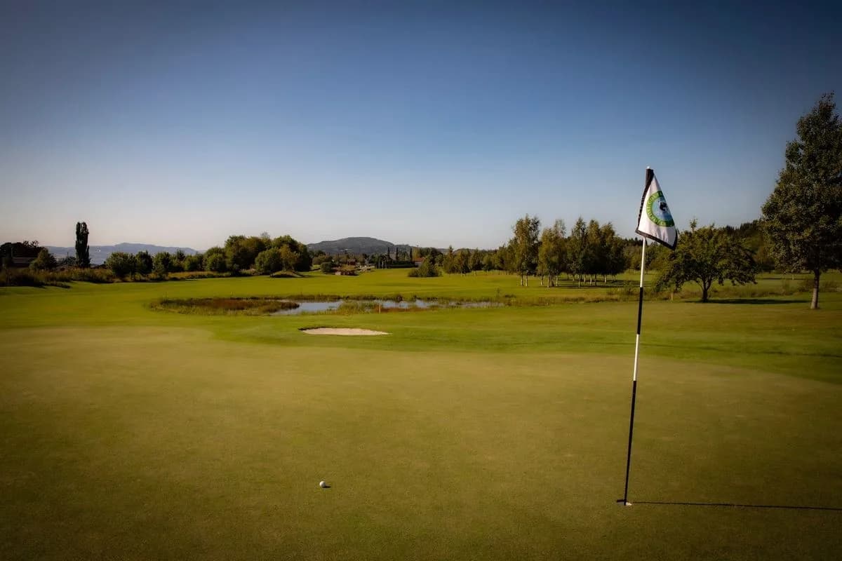 View over the golf course at Stjørdal Golf Club with fairways and forested hills