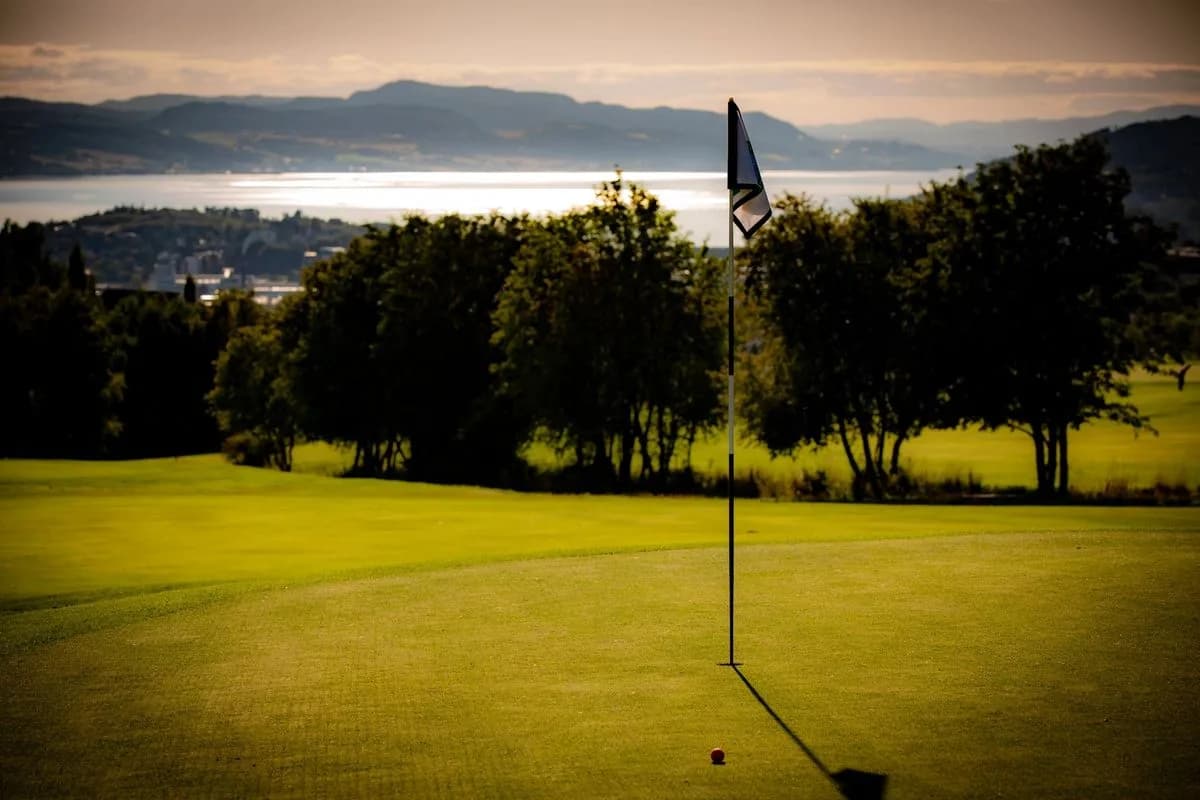 Green with bunker at Stjørdal Golf Club surrounded by forest and natural terrain
