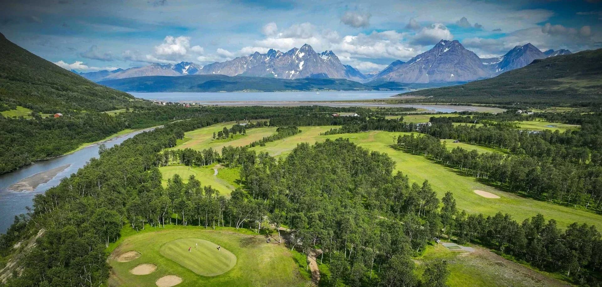 Aerial view of Tromsø Golf Club with Lyngsalpene mountains and fjord in the background, world's northernmost 18-hole golf course
