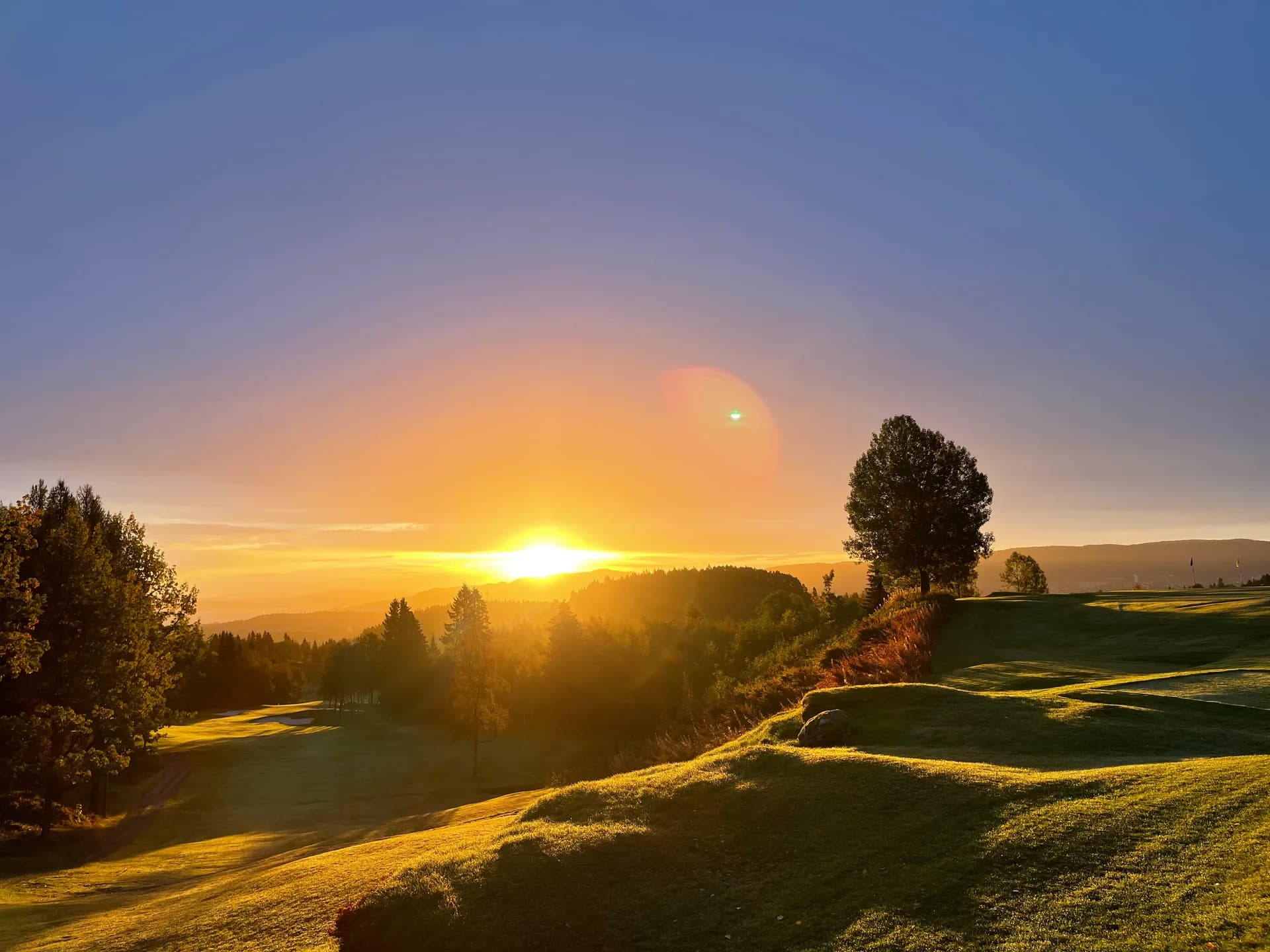 Trondheim Golf Club in evening sun with view over the course and Bymarka forest